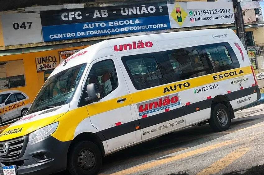 Van da CFC União estacionada em frente à sede da autoescola, com a fachada CFC AB União Auto Escola ao fundo